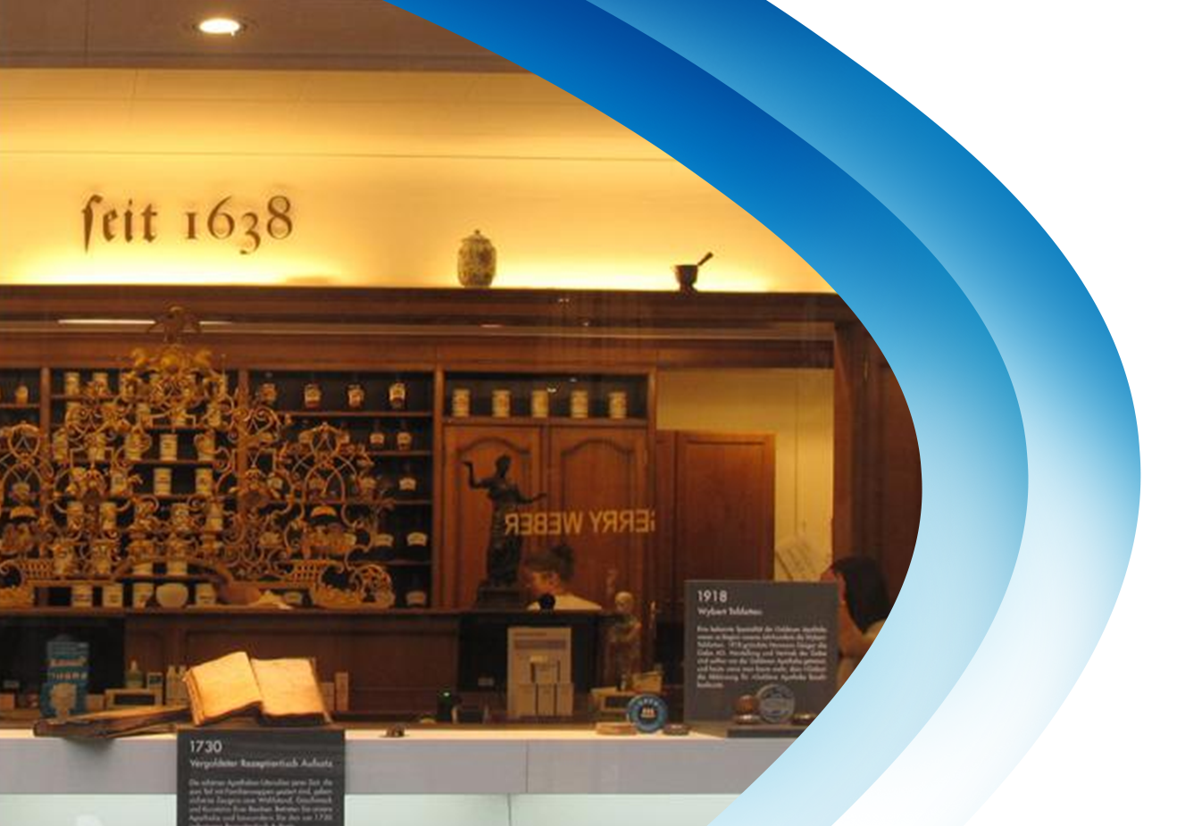 Historický interiér lékárny s dřevěnými policemi s nápisem „Feit 1638" a poličkou s tradičními nádobami.